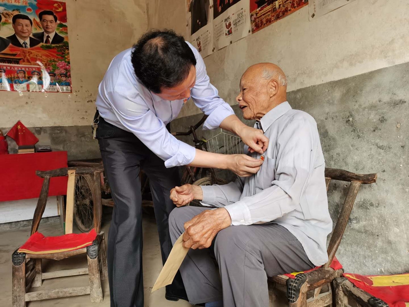 胡书记为建国前老党员佩戴党徽.jpg 胡书记为建国前老党员佩戴党徽.jpg